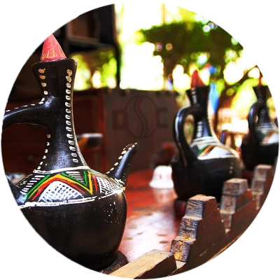 3 black ethiopian coffee pots with traditional patterns in a row with dilbi coffee exporters logo in background